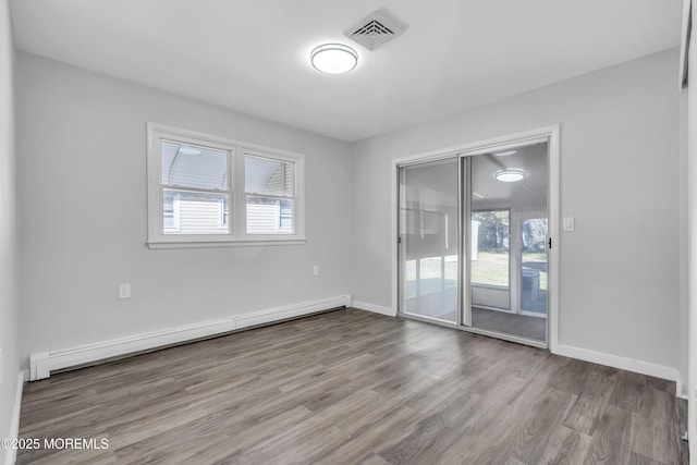 spare room with a baseboard radiator, light hardwood / wood-style flooring, and plenty of natural light