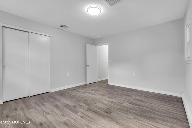 unfurnished bedroom featuring light wood-type flooring and a closet