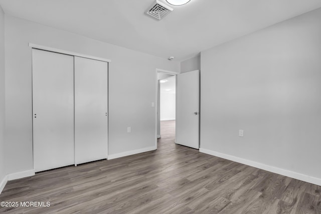 unfurnished bedroom with a closet and light hardwood / wood-style flooring