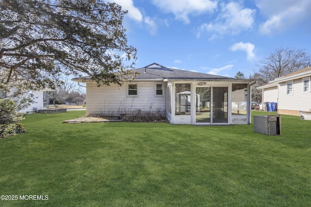 rear view of house with a sunroom and a yard