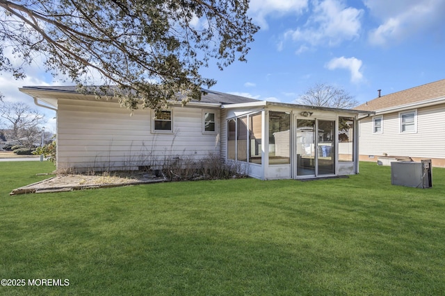 back of property featuring a lawn and a sunroom