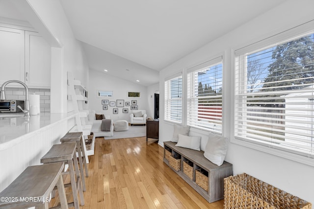 living room featuring light wood-type flooring and vaulted ceiling