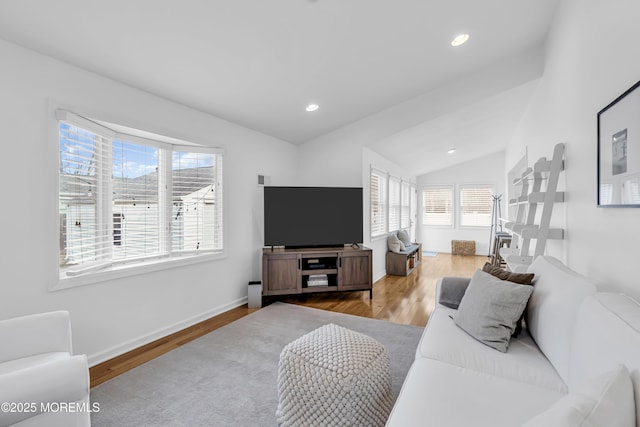 living room with light wood-type flooring and vaulted ceiling