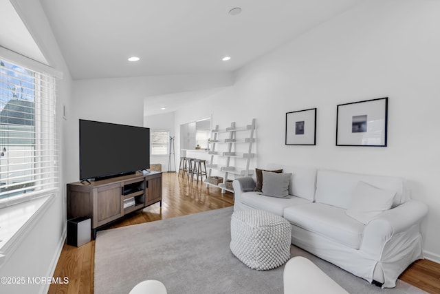 living room with lofted ceiling, plenty of natural light, and light hardwood / wood-style flooring