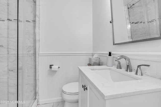 bathroom with toilet, vanity, and a shower with door