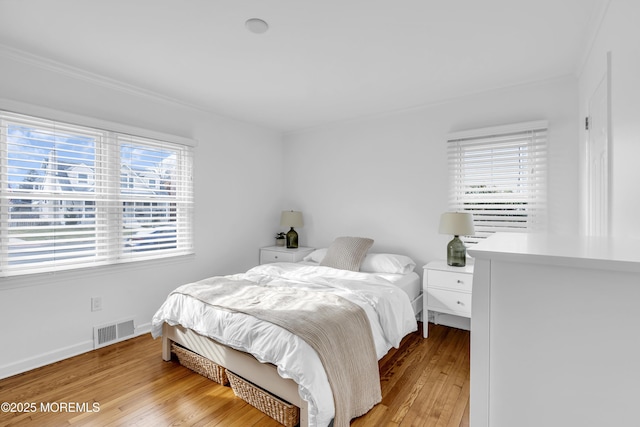 bedroom featuring light hardwood / wood-style flooring and multiple windows