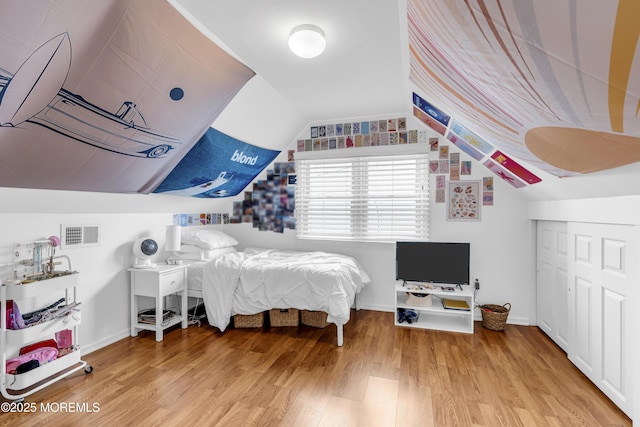 bedroom with wood-type flooring and vaulted ceiling