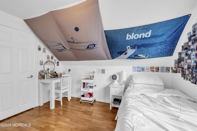 bedroom featuring vaulted ceiling and hardwood / wood-style flooring