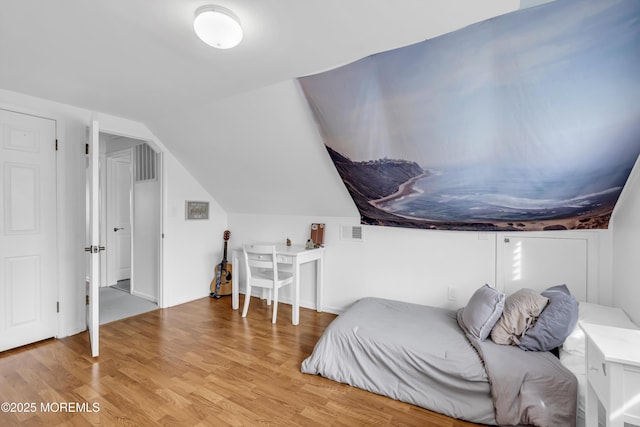 bedroom with lofted ceiling and light hardwood / wood-style flooring