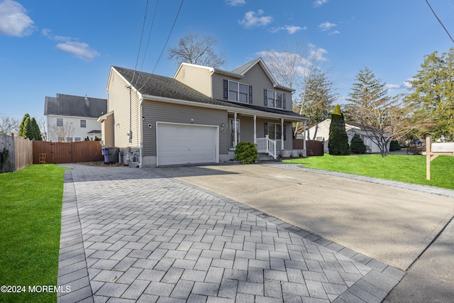 view of property with covered porch, a front lawn, and a garage