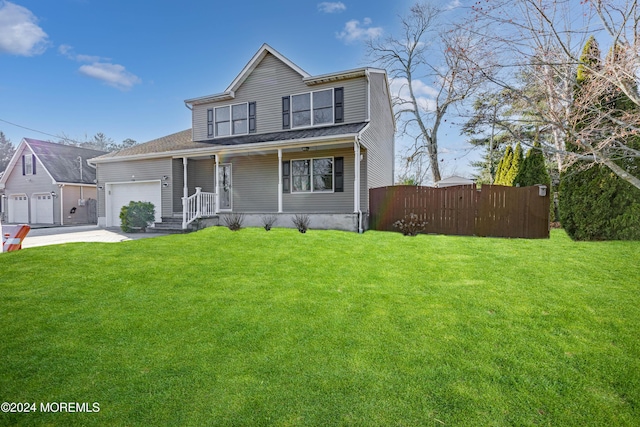 view of front of house featuring a front yard, a garage, and covered porch