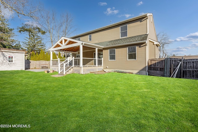 rear view of property featuring a lawn