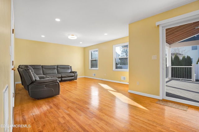 living room featuring lofted ceiling and light hardwood / wood-style floors