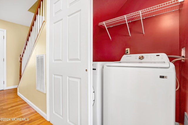 washroom featuring washing machine and dryer and hardwood / wood-style flooring