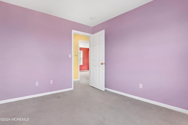 unfurnished room featuring light colored carpet