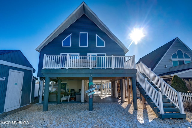 back of property featuring a storage shed, a wooden deck, and a patio