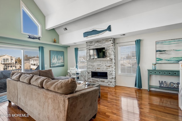 living room featuring lofted ceiling, a fireplace, and hardwood / wood-style flooring