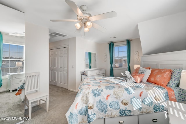 bedroom featuring light colored carpet, ceiling fan, and a closet