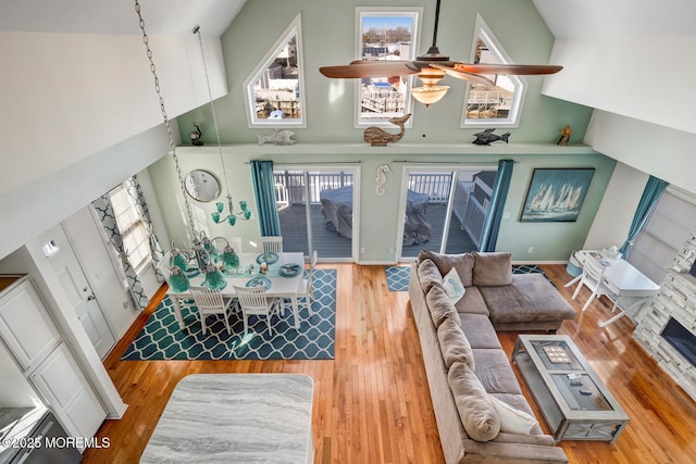 living room with ceiling fan, high vaulted ceiling, and hardwood / wood-style flooring