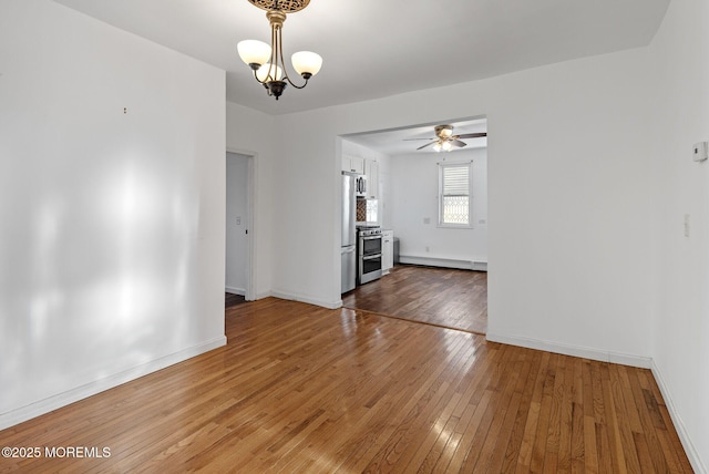 interior space featuring ceiling fan with notable chandelier and dark hardwood / wood-style flooring