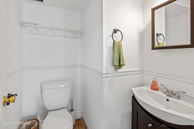 bathroom with toilet, tile patterned floors, and vanity