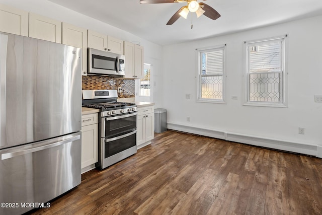 kitchen with decorative backsplash, a baseboard radiator, white cabinetry, and appliances with stainless steel finishes