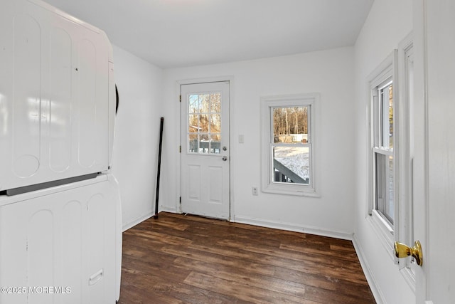 entryway featuring stacked washing maching and dryer and dark hardwood / wood-style floors