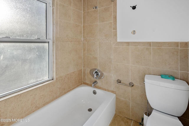 bathroom featuring toilet, shower / tub combination, and tile walls