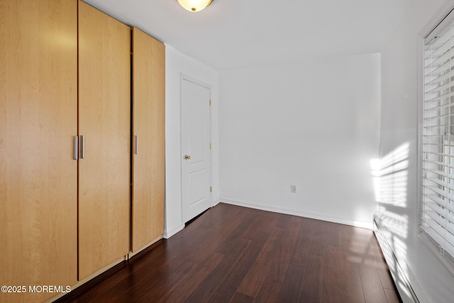 unfurnished bedroom featuring dark hardwood / wood-style flooring and a closet