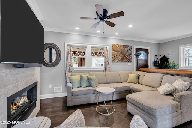 living room featuring dark wood-type flooring, plenty of natural light, and crown molding