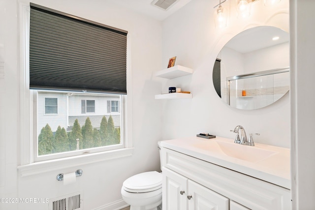 bathroom featuring visible vents, vanity, an enclosed shower, and toilet