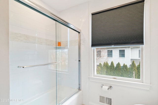 bathroom featuring visible vents and shower / bath combination with glass door