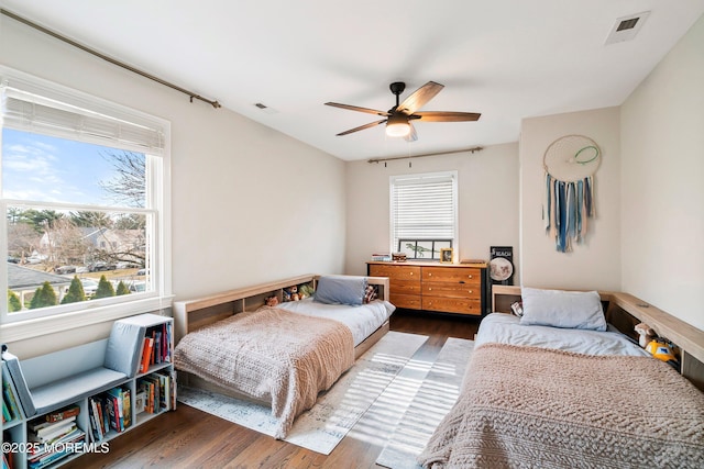 bedroom with visible vents, ceiling fan, and wood finished floors