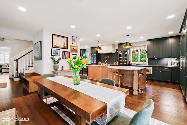 dining area with dark wood-type flooring, recessed lighting, and stairway