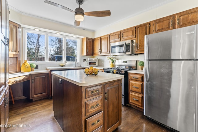 kitchen featuring ceiling fan, dark hardwood / wood-style floors, a kitchen island, crown molding, and appliances with stainless steel finishes