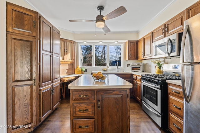 kitchen with a center island, dark wood-type flooring, stainless steel appliances, sink, and crown molding