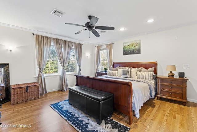 bedroom with ceiling fan, crown molding, and light hardwood / wood-style floors