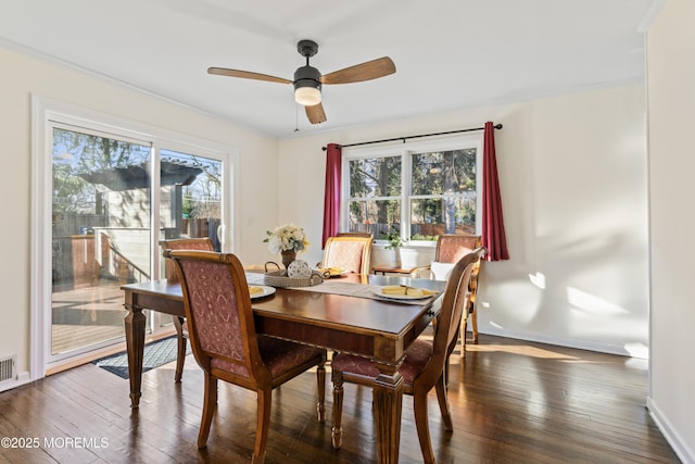 dining area with dark wood-type flooring and ceiling fan