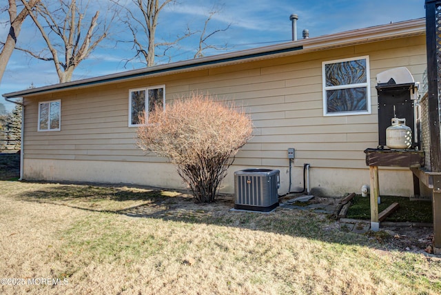 view of home's exterior with cooling unit and a yard