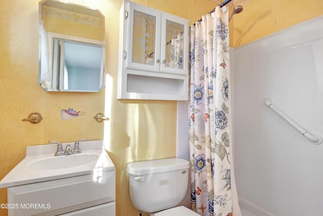 bathroom with toilet, vanity, and curtained shower