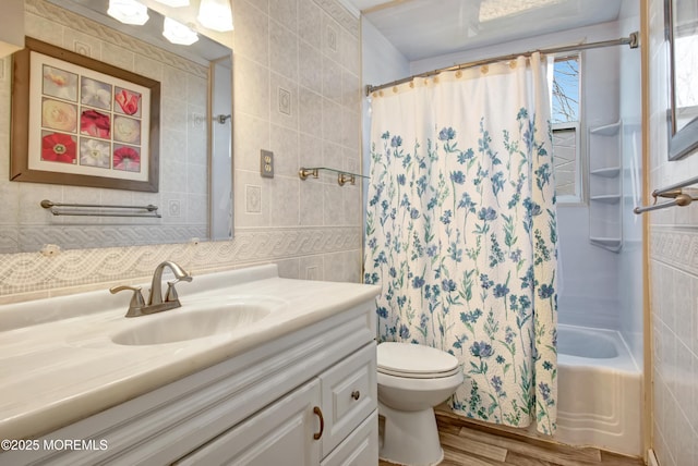 full bathroom with toilet, shower / bath combo, vanity, and tile walls