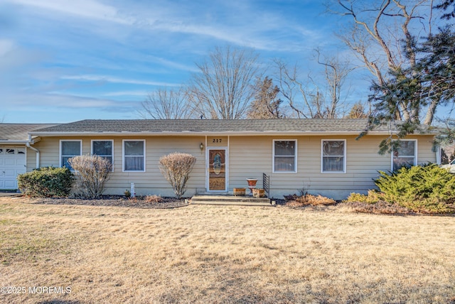 ranch-style house featuring a front lawn and a garage