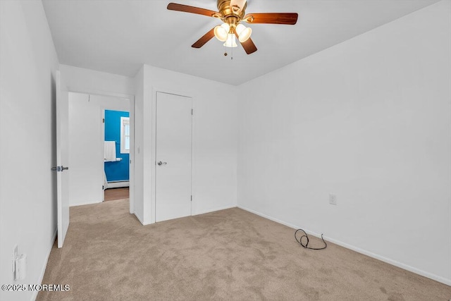 carpeted empty room with a baseboard heating unit and ceiling fan