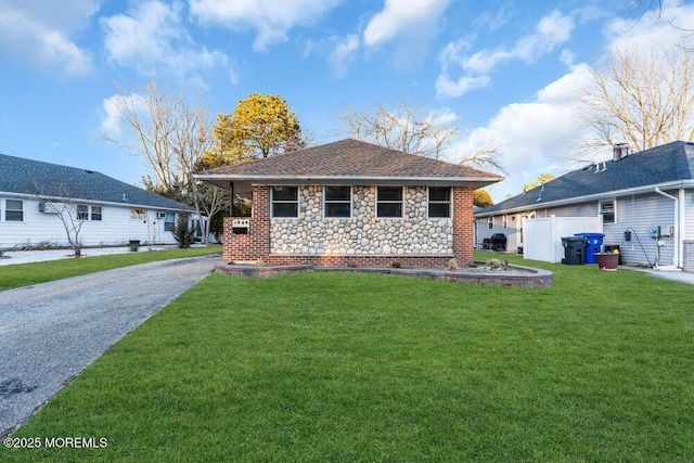 single story home featuring a front lawn