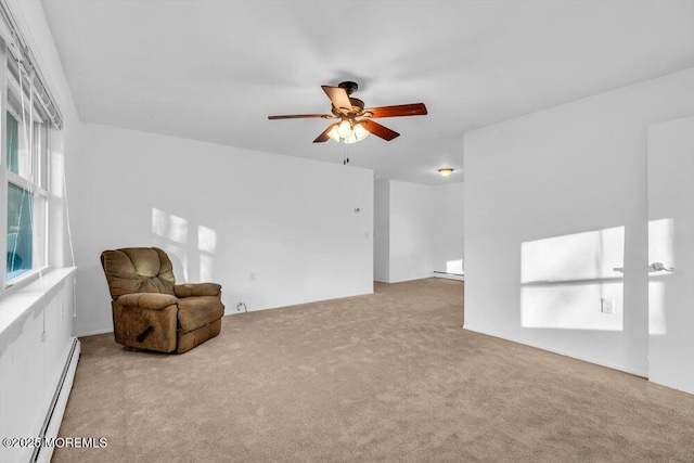 unfurnished room with a baseboard heating unit, light colored carpet, and ceiling fan