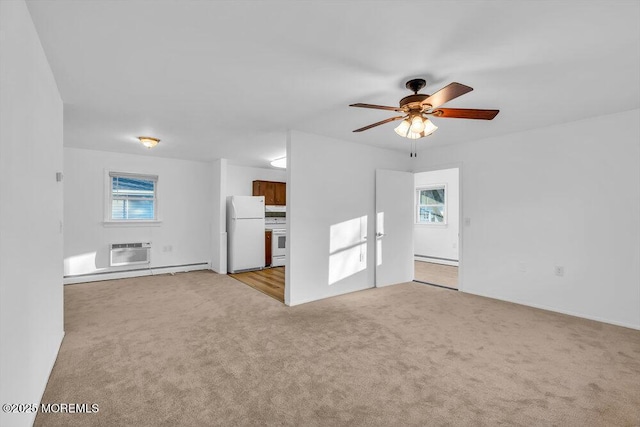 unfurnished room featuring a healthy amount of sunlight, ceiling fan, a wall mounted air conditioner, and light carpet