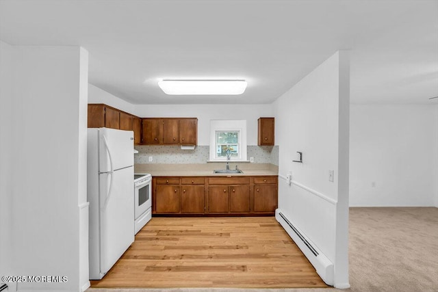 kitchen featuring sink, white appliances, a baseboard heating unit, and backsplash