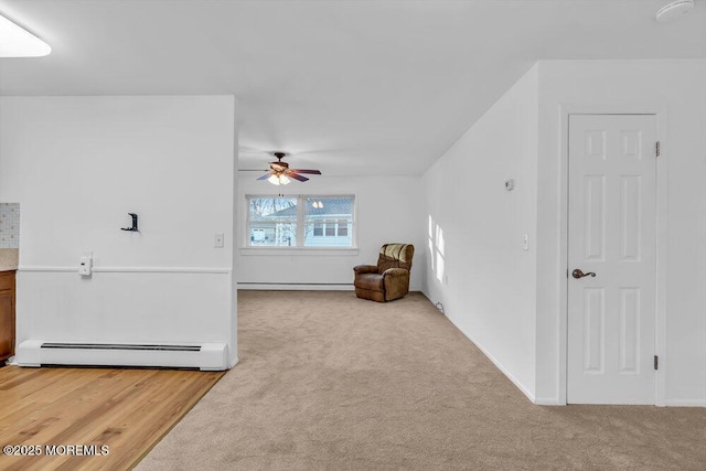 additional living space featuring ceiling fan, light carpet, and a baseboard radiator