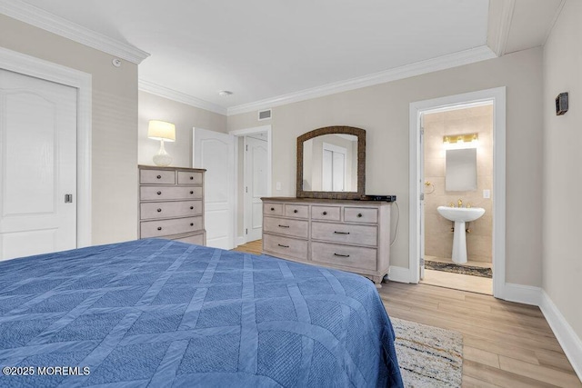 bedroom with ornamental molding, light hardwood / wood-style flooring, and connected bathroom