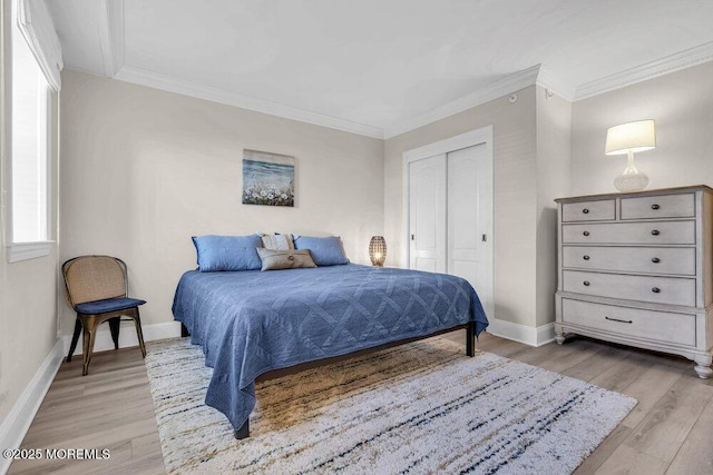 bedroom with light hardwood / wood-style floors, ornamental molding, and a closet